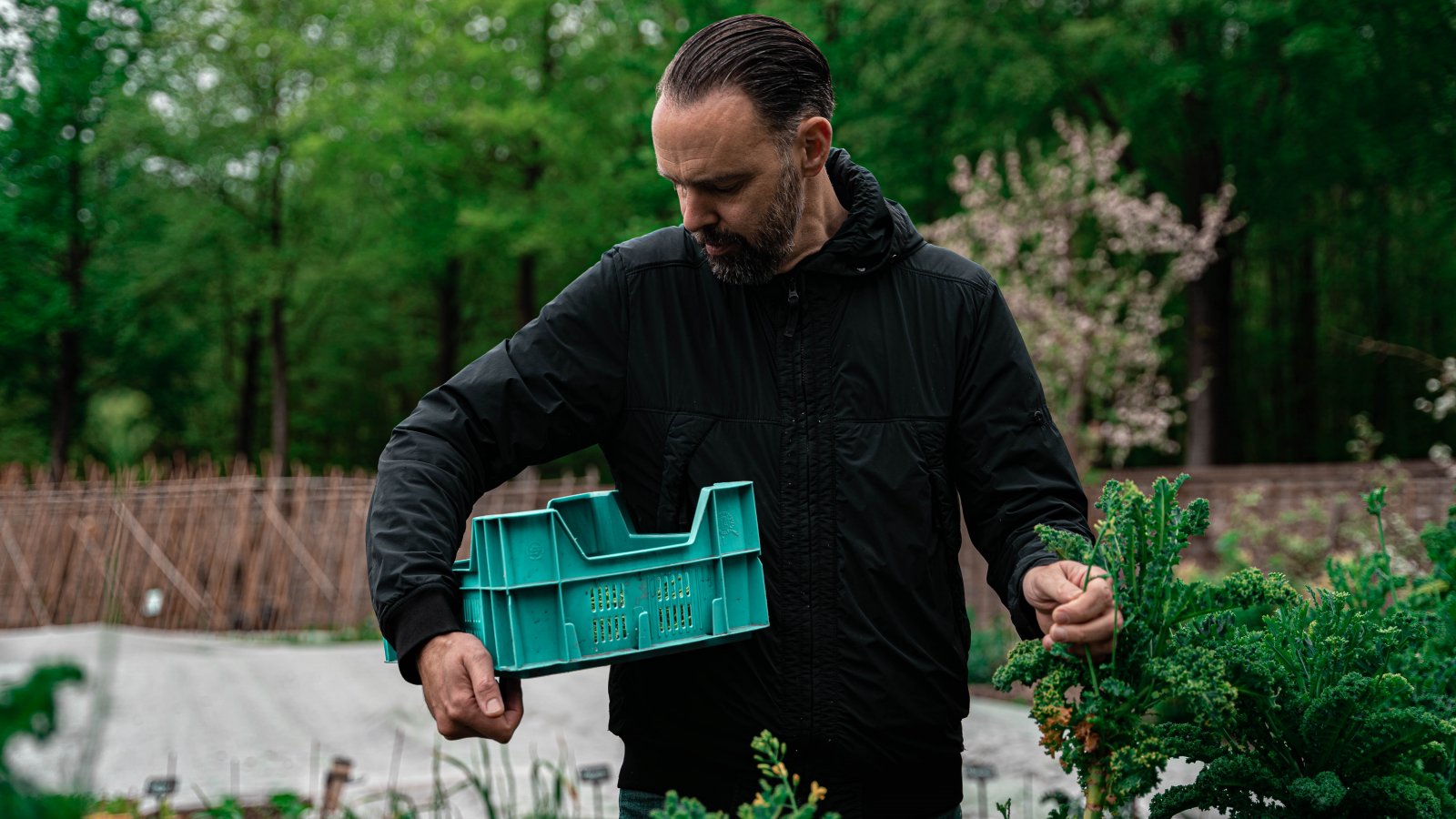 Emile van der Staak met blauwe krat in tuin