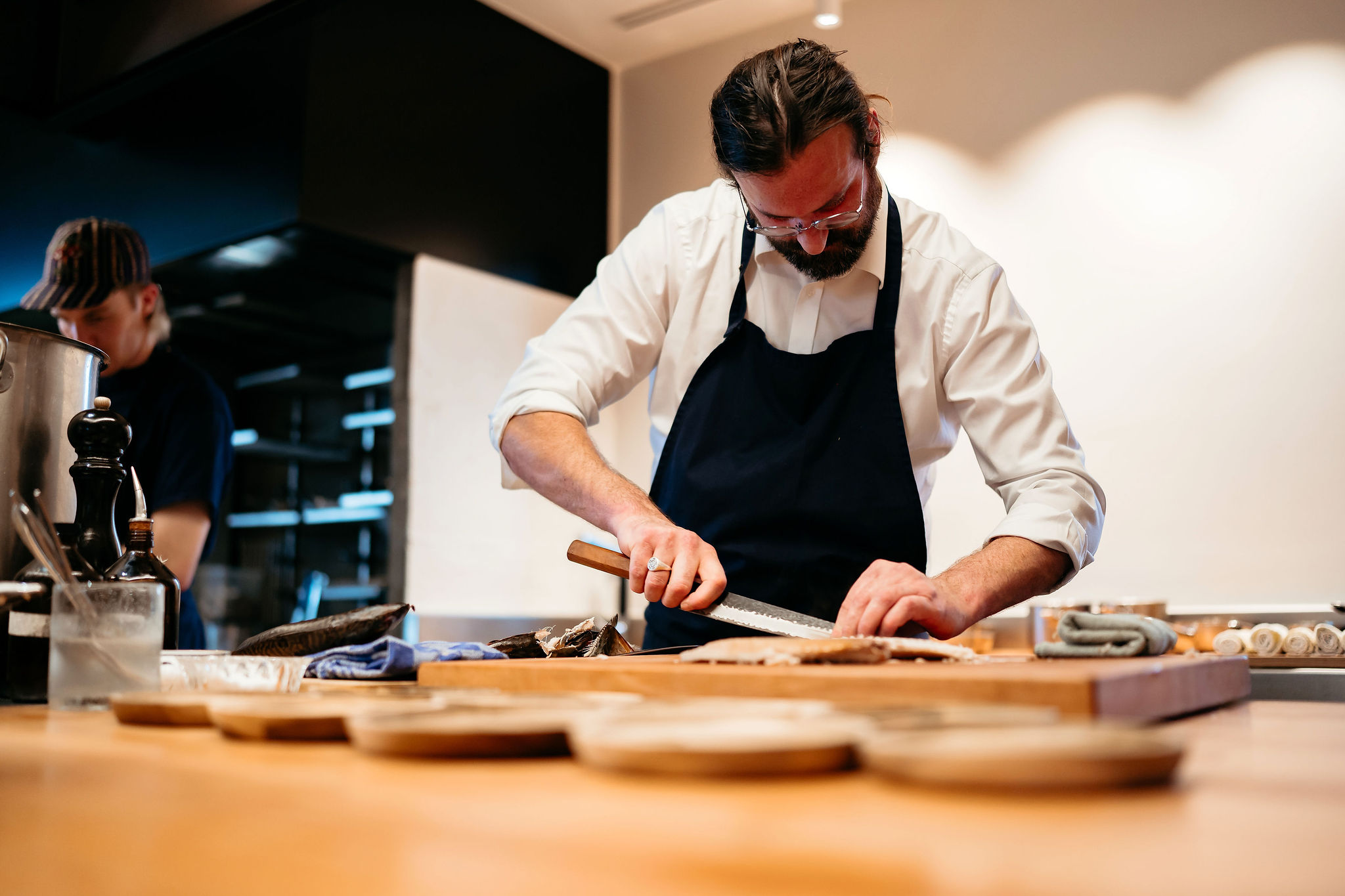 Willem Hiele die de makreel fileert in de keuken