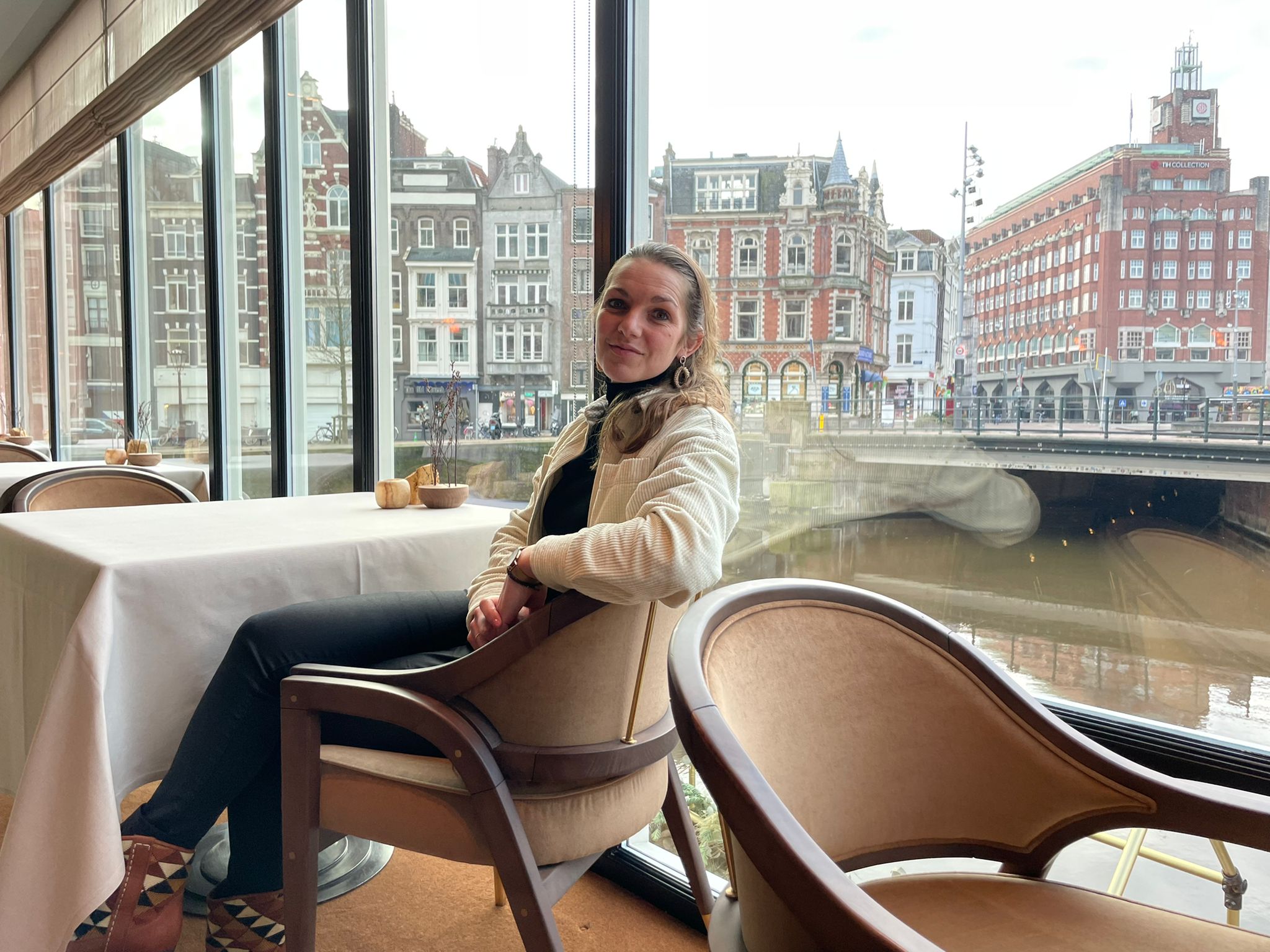 Maaike bij Restaurant Flore, met op de achtergrond een rustig Amsterdam