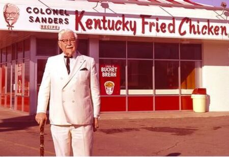 Harland Sanders voor een van zijn KFC-restaurants